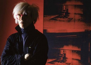 8_Alberto Venzago_Andy Warhol posiert vor dem Bild Little Electric Chair_1964 1965_Factory_Union Square West_New York_1984_copyright Alberto Venzago.jpg