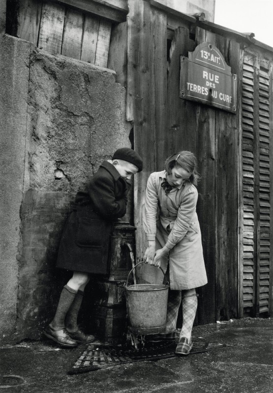 Enfants prenant de l‘eau à la fontaine, rue des Terres-au-Curé, Paris, 1954 © Sabine Weiss