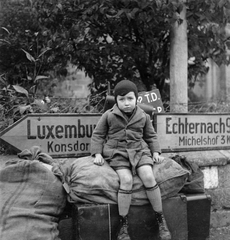 3_Copyright_LeeMillerArchives_Small_tired_boy_[Raymond_Melchers_aged_7]_waits_at_cross_roads_for_transport_Bech_Luxembourg_1945