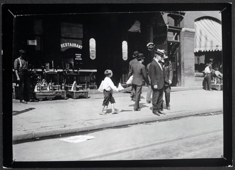 Lewis Hine, Candid shot of Newsie selling papers on street, 1912